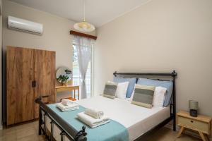 a bedroom with a bed and a window at Flora Beach House in Kremasti