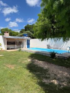 a swimming pool in a yard with a building at Rincón de Juanita in Rivera