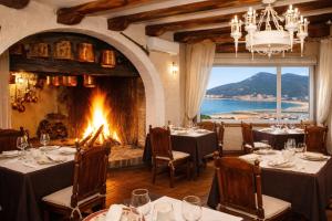 a dining room with tables and a fireplace at Hotel Risco in Laredo