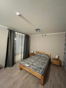 a bedroom with a bed and a large window at FAMILY HOUSE MARUPE in Mārupe
