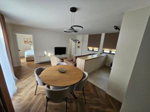 a kitchen and living room with a table and chairs at Loft Apartment in Podgorica +7 photos