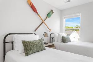 a bedroom with two beds and two oars on the wall at The Trendy In Park Circle Mins to DT CHS & Beach in Charleston +24 photos