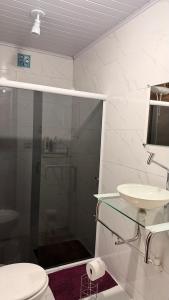 a bathroom with a shower and a toilet and a sink at Casa vista infinita in Mangaratiba +31 photos