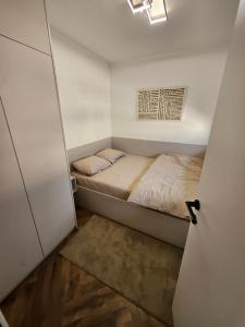 a small bedroom with a bed and a door at Loft Apartment in Podgorica