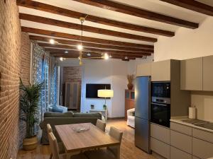 a kitchen and living room with a wooden table in a room at OLYMPIC VILLAGE in Barcelona