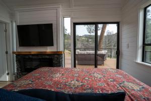 a bedroom with a bed and a television and a fireplace at River Falls Retreat in Oakhurst