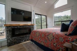 a bedroom with a bed and a fireplace and a tv at River Falls Retreat in Oakhurst