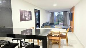 a dining room and living room with a table and chairs at Recanto da Praia in Anchieta