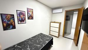 a bedroom with a bed and pictures on the wall at Recanto da Praia in Anchieta
