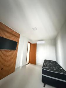 a bedroom with a bed and a wooden door at Recanto da Praia in Anchieta