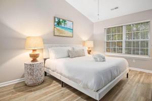a bedroom with a white bed and two lamps at The Suite Carolinas in Charleston