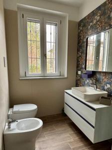 a bathroom with a toilet and a sink and a window at NessunConfine Casa Laura in Santa Giuletta