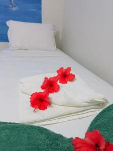 two white beds with red flowers on them at Pousada São Silmares in Fernando de Noronha +112 photos