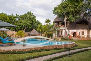 a resort with a pool and a house at Villa Kapungu with private C h e f, XXL pool & garden in Diani Beach