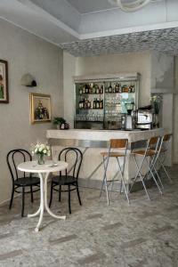 a bar with chairs and a table and a counter at Hotel Brezza Nuova Gestione in Rimini