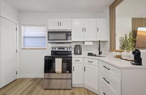 a kitchen with white cabinets and a black stove top oven at La Casita St Pete in St. Petersburg