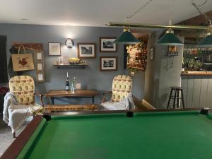 a room with a pool table and two chairs at Kings Head - Riverside, Ravenstonedale in Ravenstonedale