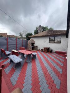 a patio with picnic tables and benches and a building at Countryview Chalet in Benoni