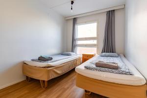 two beds in a room with a window at Kalastajankuja Apartment in Espoo
