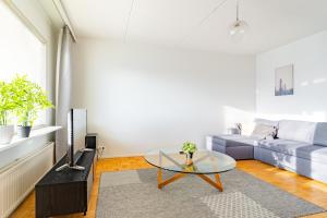 a living room with a couch and a glass table at Kalastajankuja Apartment in Espoo +10 photos