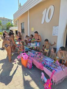 a group of people in bathing suits at a beach at Hotel Brezza Nuova Gestione in Rimini