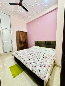 ein Schlafzimmer mit einem Bett und einer rosa Wand in der Unterkunft Narayan Square in Bhilwāl