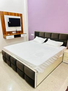ein großes Bett in einem Zimmer mit Fernseher in der Unterkunft Narayan Square in Bhilwāl