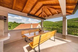 a wooden bench on the balcony of a house at Villa Argenta in Aržano