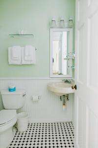 a bathroom with a toilet and a sink and a mirror at Curry Mansion Inn in Key West