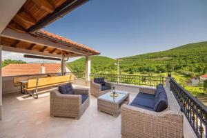 a patio with wicker chairs and a table with a view at Villa Argenta in Aržano