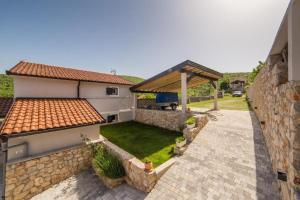 a backyard of a house with a stone wall at Villa Argenta in Aržano