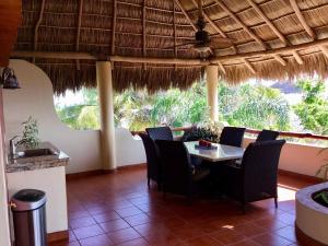 a dining room with a table and chairs in a restaurant at Beautiful Tropical House with Ocean VIEWS! in Cruz de Huanacaxtle