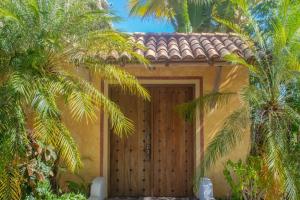 a house with a wooden door and palm trees at Beautiful Tropical House with Ocean VIEWS! in Cruz de Huanacaxtle