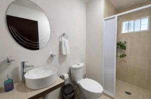 a bathroom with a sink and a toilet and a mirror at Hotel El Balcón in Zacatlán