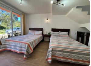 two beds sitting next to each other in a room at Hotel El Balcón in Zacatlán