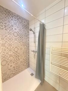 a shower with a shower curtain in a bathroom at La Pause Alpine - Centre Ville - Proche Gare in Saint-Jean-de-Maurienne