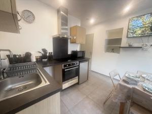 a kitchen with a sink and a stove at La Pause Alpine - Centre Ville - Proche Gare in Saint-Jean-de-Maurienne