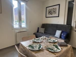 a living room with a table and a couch at La Pause Alpine - Centre Ville - Proche Gare in Saint-Jean-de-Maurienne +9 photos
