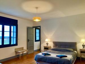 a bedroom with a bed and two tables and a window at VILLA CLEMENTINE in Aignan