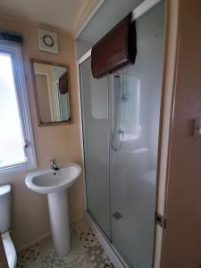 a bathroom with a sink and a shower at Willows Lodge with self contained garden in Carlisle +8 photos