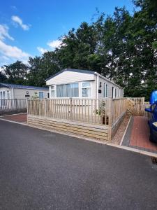 a wooden fence in front of a house at Willows Lodge with self contained garden in Carlisle