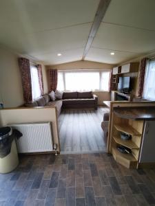 a living room with a couch and a table at Willows Lodge with self contained garden in Carlisle