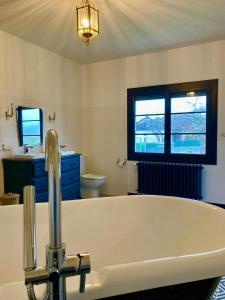 a bathroom with a bath tub and a sink at VILLA CLEMENTINE in Aignan +36 photos
