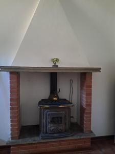 a brick fireplace with a stove in a room at L'edera in Tuscania