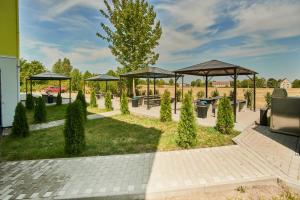 a picnic area with benches and umbrellas in a park at Hotel City Inn in Magdeburg