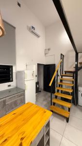 a kitchen with a wooden table and a staircase at Loft Horizonte Viedma in Viedma