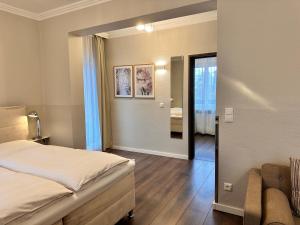 a bedroom with a bed and a living room at Hotel Villa Solln - free parking in Munich