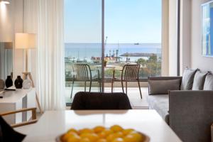 a living room with a table and a view of the ocean at L Residences & Suites in Larnaca