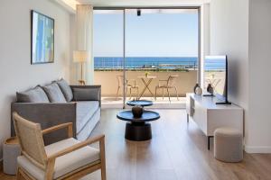 a living room with a couch and a view of the ocean at L Residences & Suites in Larnaca