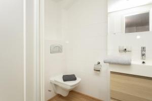 a white bathroom with a toilet and a sink at Penzion Quest in Loket +35 photos